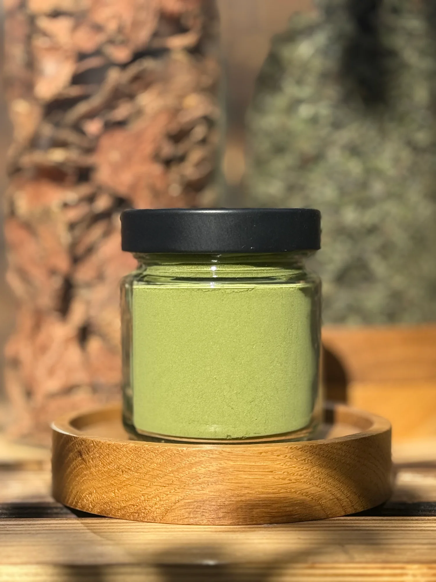 Ziołowa matcha Kornino w szklanym słoiczku na drewnianej podstawce